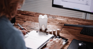 A woman balances her budget in front of a computer.
