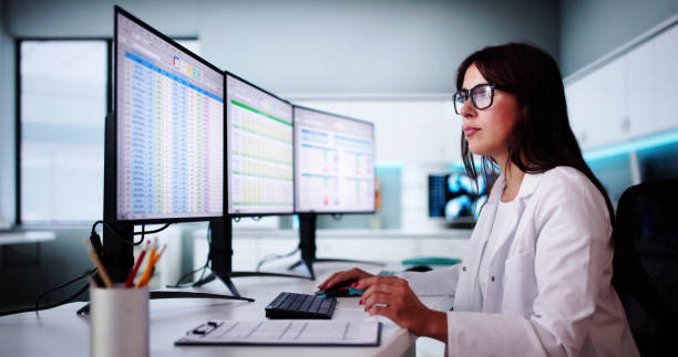 A healthcare worker inputs numbers into a spreadsheet on her computer. 